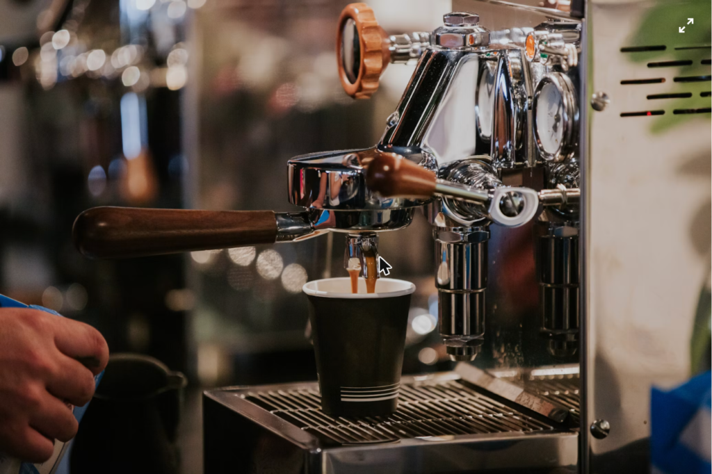 Hot espresso being extracted from the machine, the base for shakerato coffee
