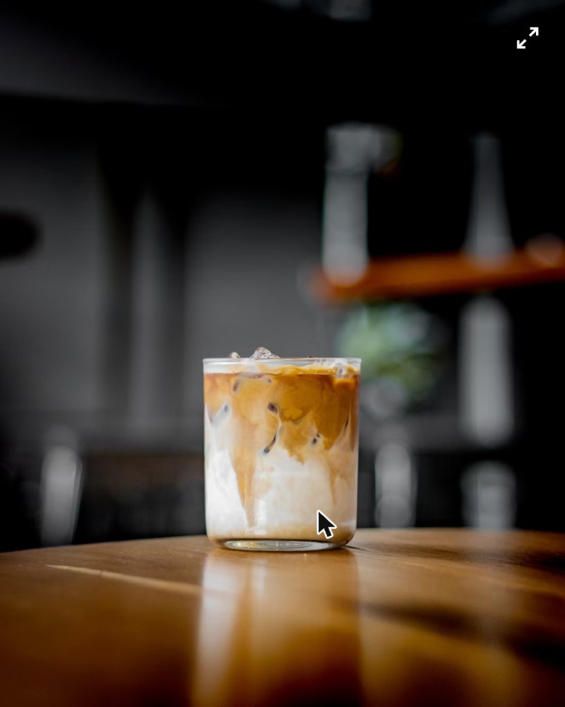 Finished shakerato coffee served in a chilled glass on a wooden table
