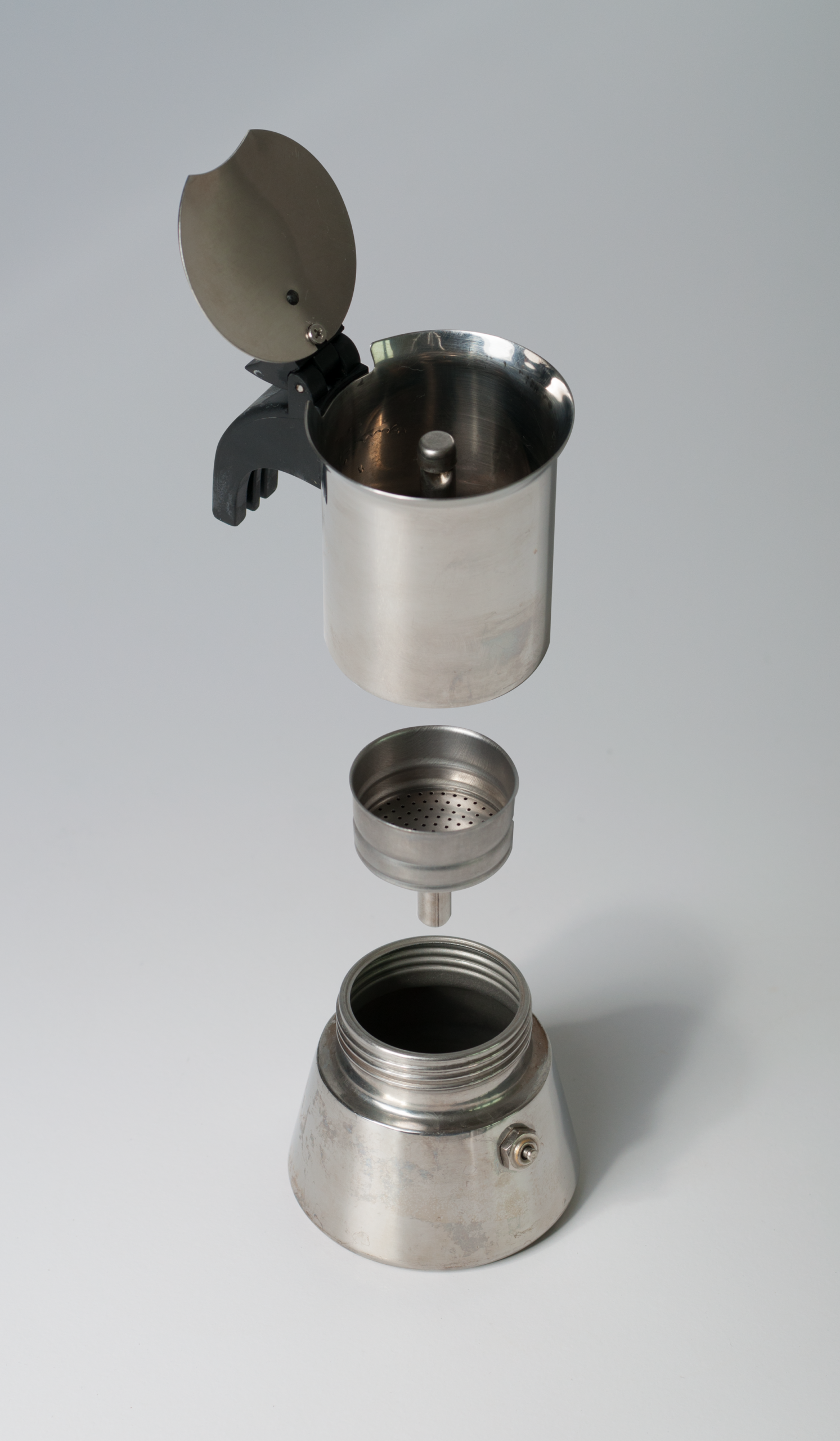 Moka pot parts disassembled: base, funnel filter and upper chamber