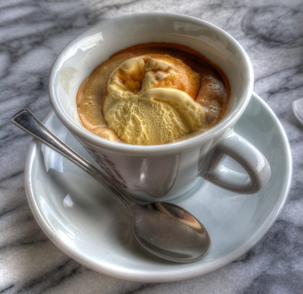 Affogato al caffè served in a white cup with gelato drowned in espresso