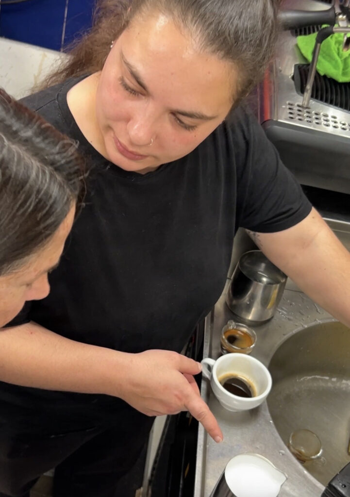 A barista demonstrates Italian coffee techniques at a training class