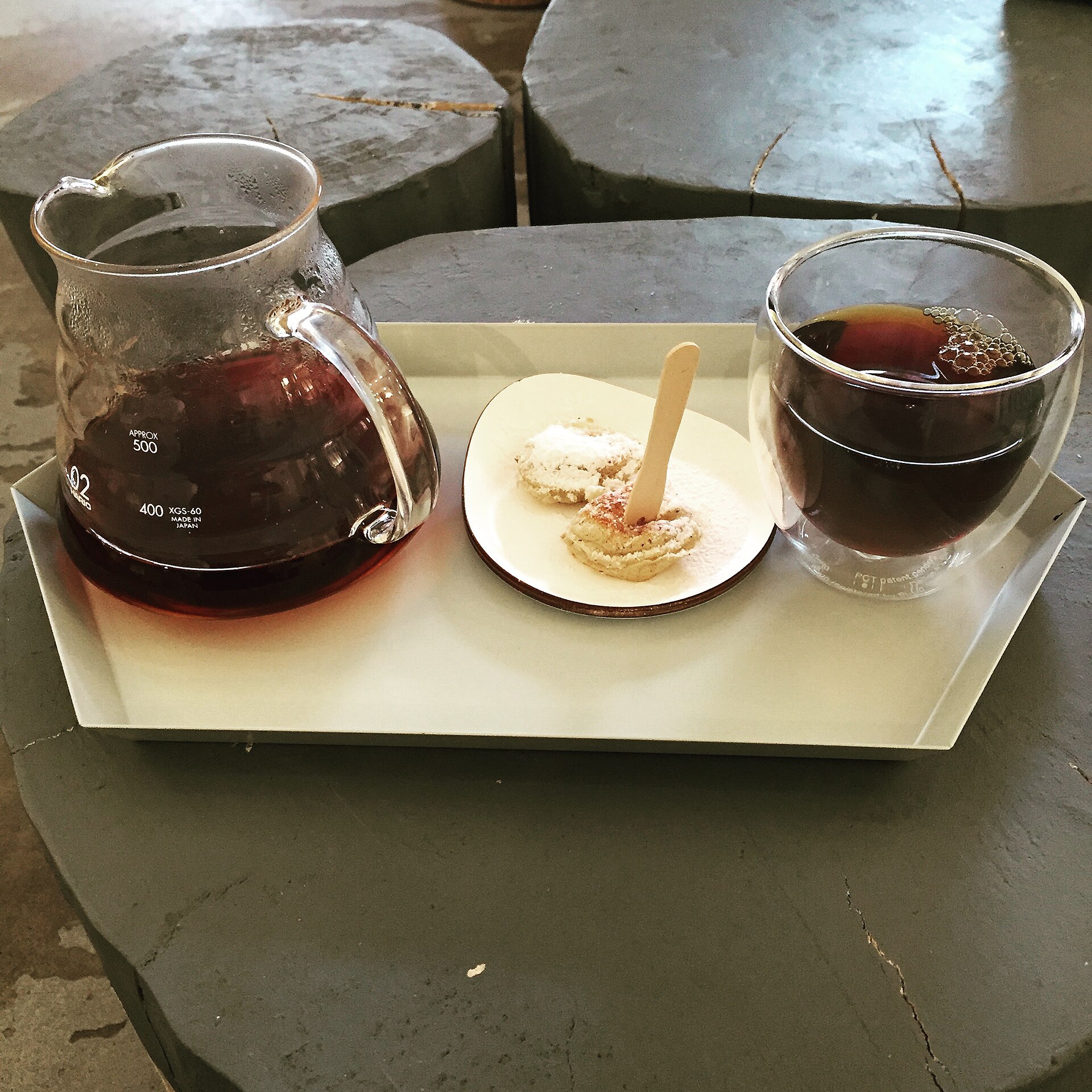 A glass carafe of V60 pour-over coffee served after the coffee bloom and full brew