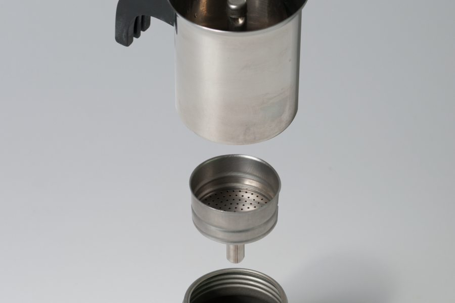 Moka pot parts disassembled: base, funnel filter and upper chamber