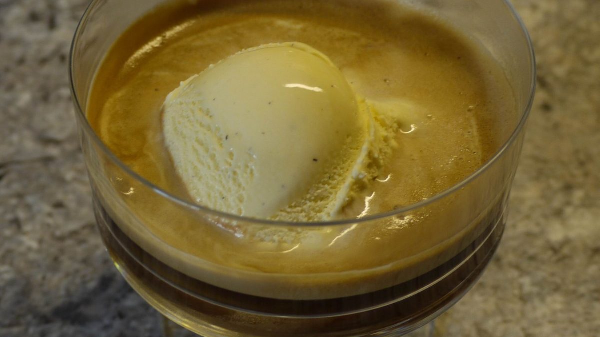 Affogato with a scoop of vanilla gelato melting into espresso in a glass