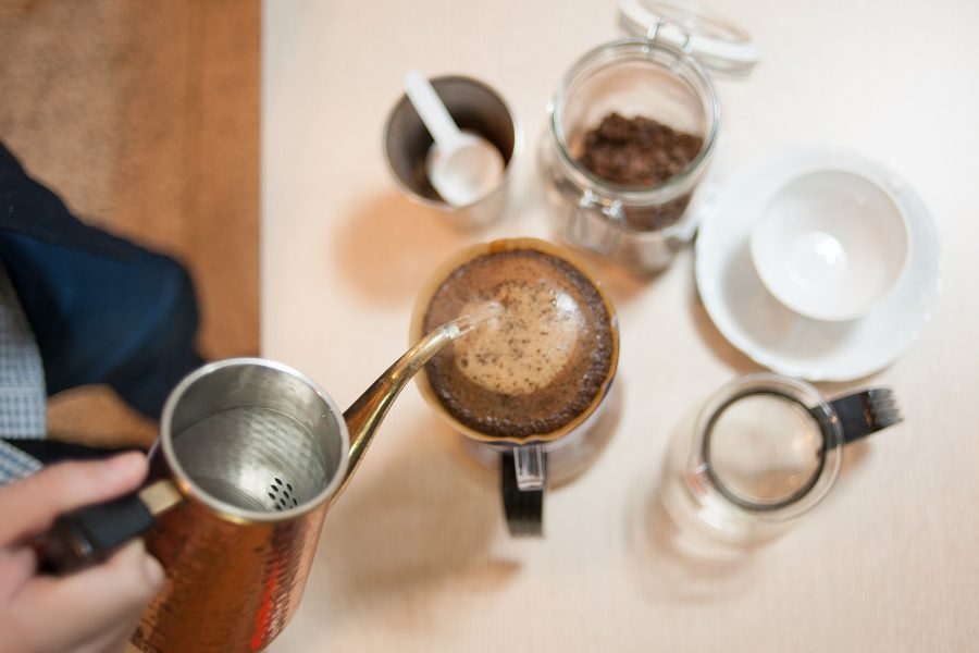 Manual drip brewing where a coffee scale tracks water weight