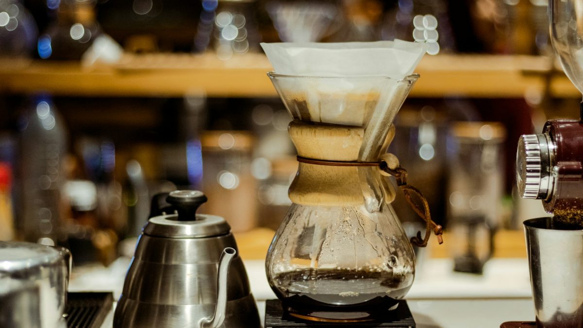 Chemex pour-over coffee maker on a café bar next to a kettle