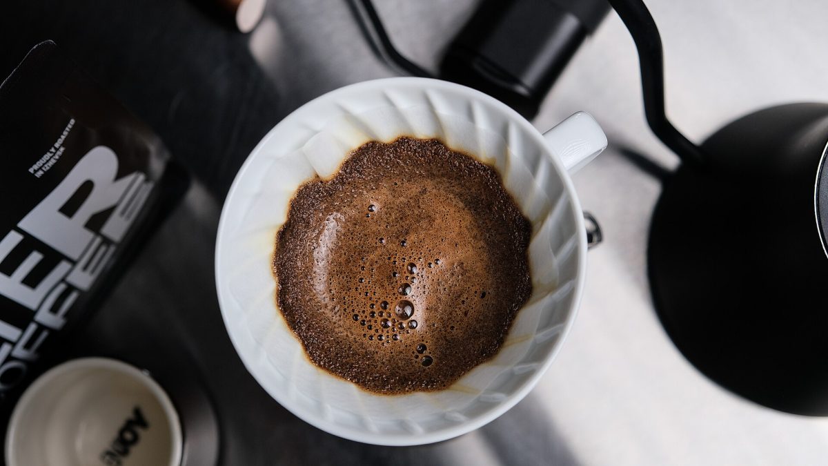 A V60 coffee bed blooming after the first pour, showing the coffee bloom as gas escapes